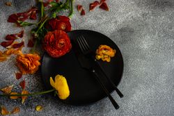 Rustic table setting with fresh red and yellow flowers