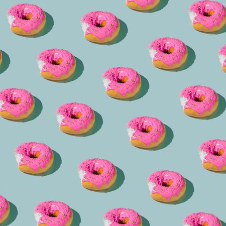 Patter of pink glazed donut on blue pastel background