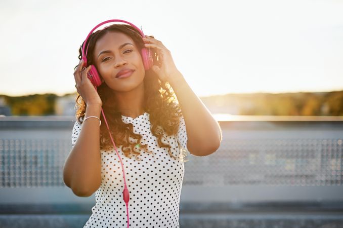 Woman listening to music wearing pink headphones