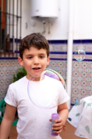 Boy playing with soap bubbles on terrace