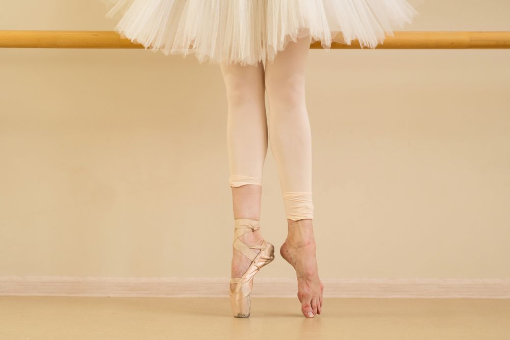Ballet dancer with one foot in pointe shoes