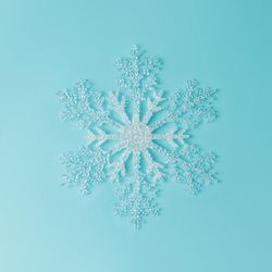 Single large snowflake on bright blue background