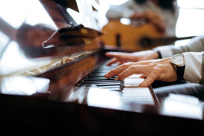 Crop male hands playing piano