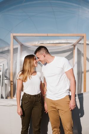 Affectionate couple looking at each other near bubble hotel