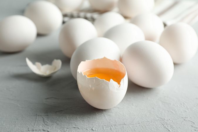 chicken eggs and kitchen towel on grey background, space for text and closeup