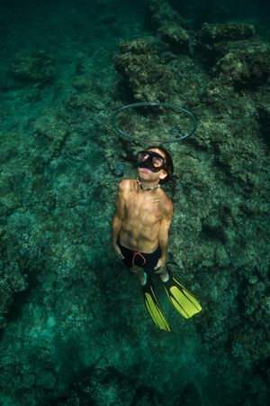 Shirtless boy swimming underwater in ocean