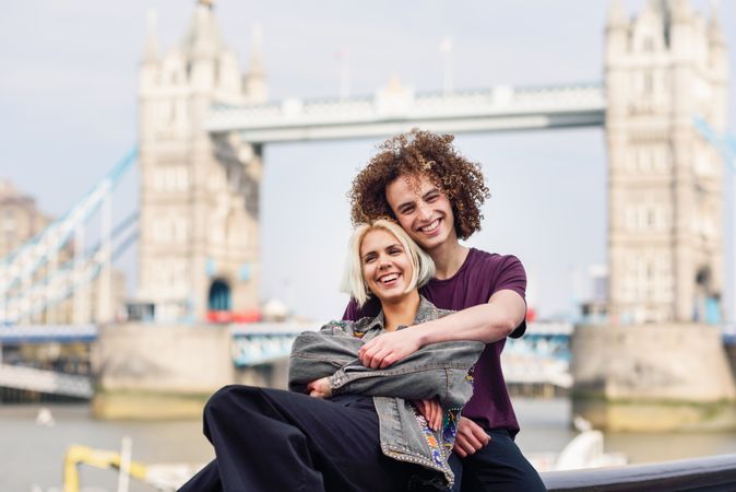 Girlfriend and boyfriend hugging in front of famous British bridge