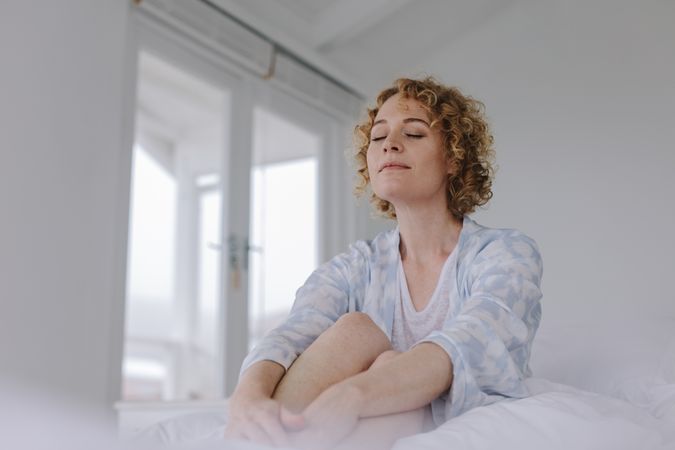 Woman sitting on bed after waking up