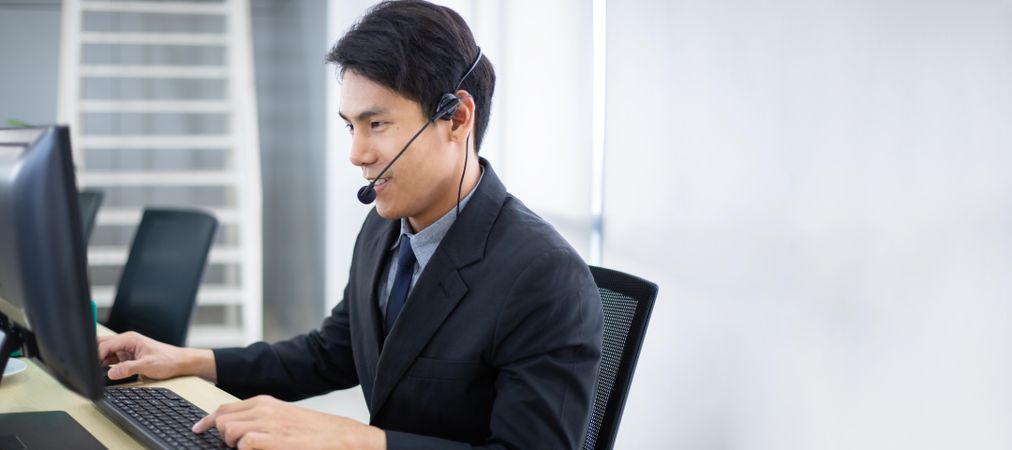 Asian business man working at service desk talking on phone