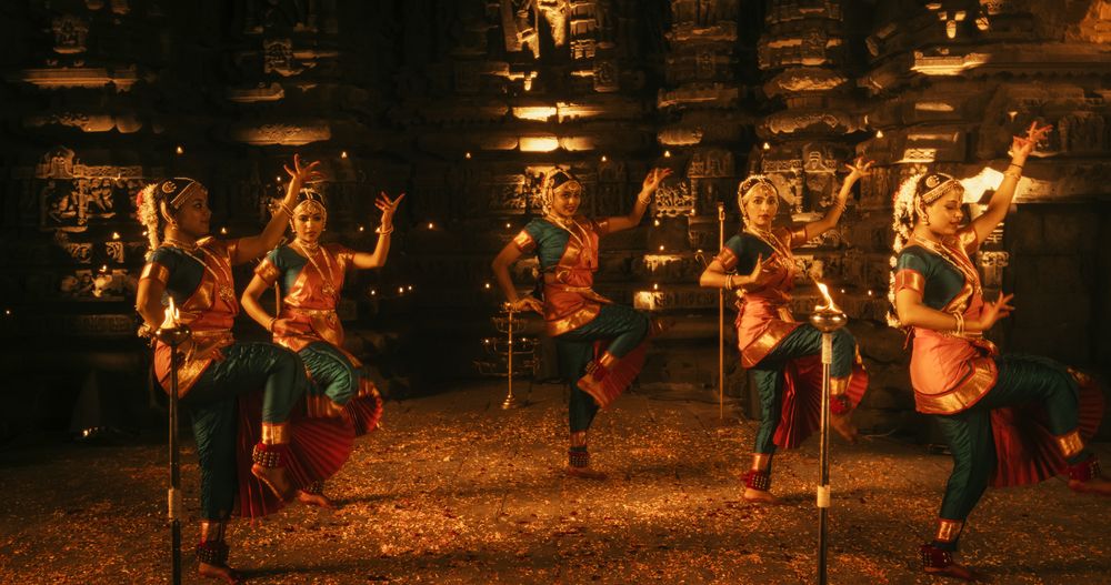 Portrait of Three Expressive Young Indian Dancers Performing Folk Dance Choreography Inside an Ancient Temple.