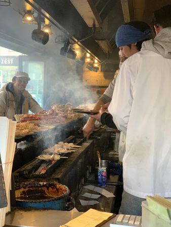 Man in chef uniform cooking meat in a kiosk