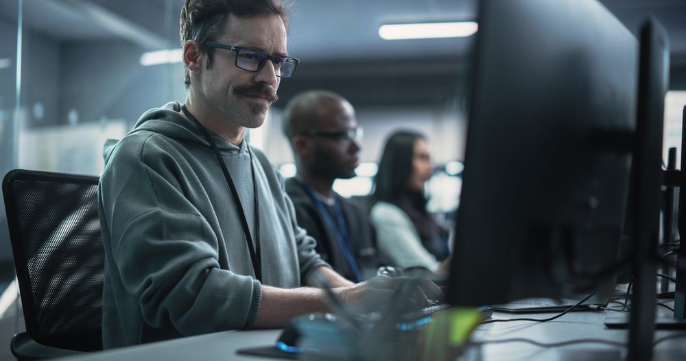 Young Passionate Specialist Working on Computer