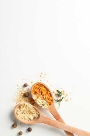 Top view of two wooden spoons full of spice, copy space, vertical composition