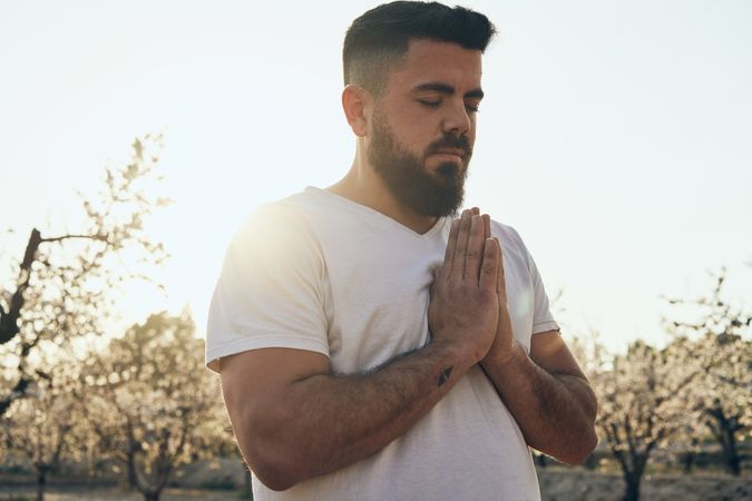 Bearded man meditating in spring garden
