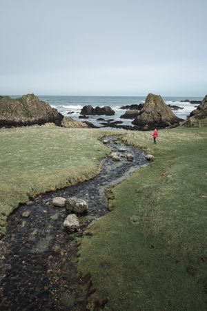 Woman walking along mountain river estuary