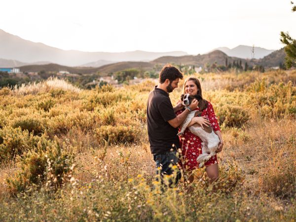 Happy couple with friendly cute dog outdoors