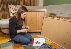Woman reading instructions to assemble furniture