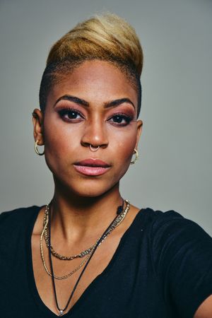 Closeup portrait of serious Black woman with short blonde hair and septum piercing