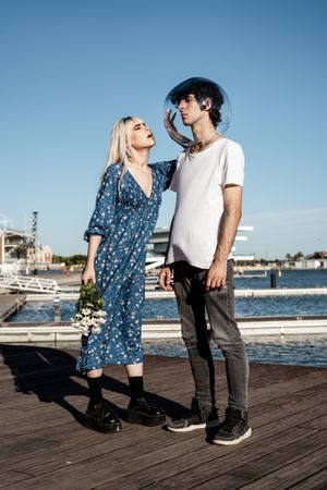 Woman touching fish bowl on head of boyfriend