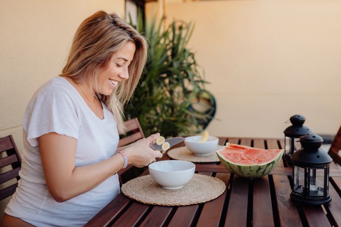 Pregnant woman cutting banana to bowl