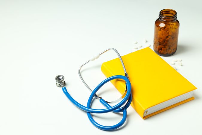 Medical literature - book and doctors accessories on light background
