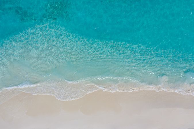 Aerial shot of clear blue water at a tropical beach with copy space