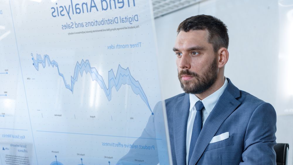 In the Near Future Successful Businessman Works on Computer with Transparent Display