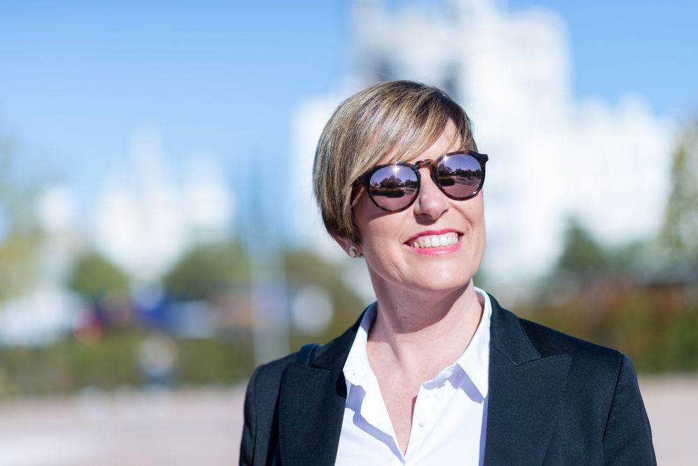 Professional woman walking outside with sunglasses