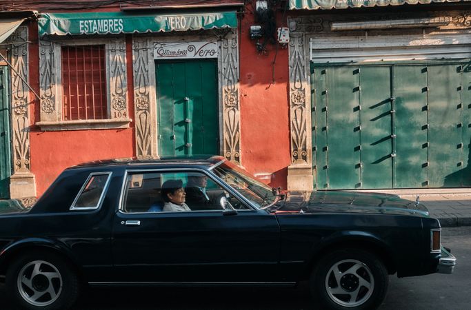 Man and woman driving in car on quiet street