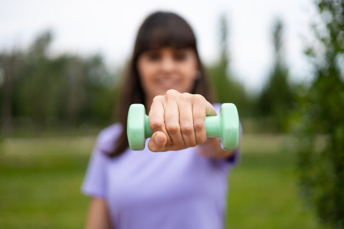 Woman doing weightlifting sport exercise outdoors