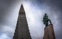 Statue and amazing church against cloudy sky