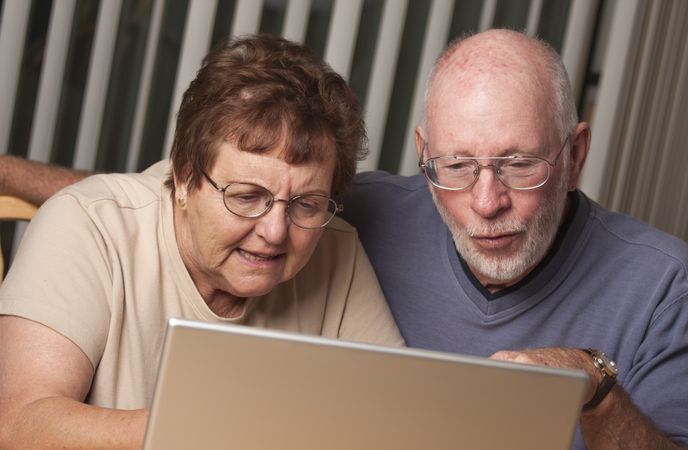 Smiling Mature Adult Couple Having Fun on the Computer