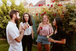Group of cheerful friends clinking glasses at party