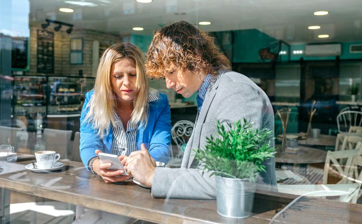 Businesswoman showing phone to coworker