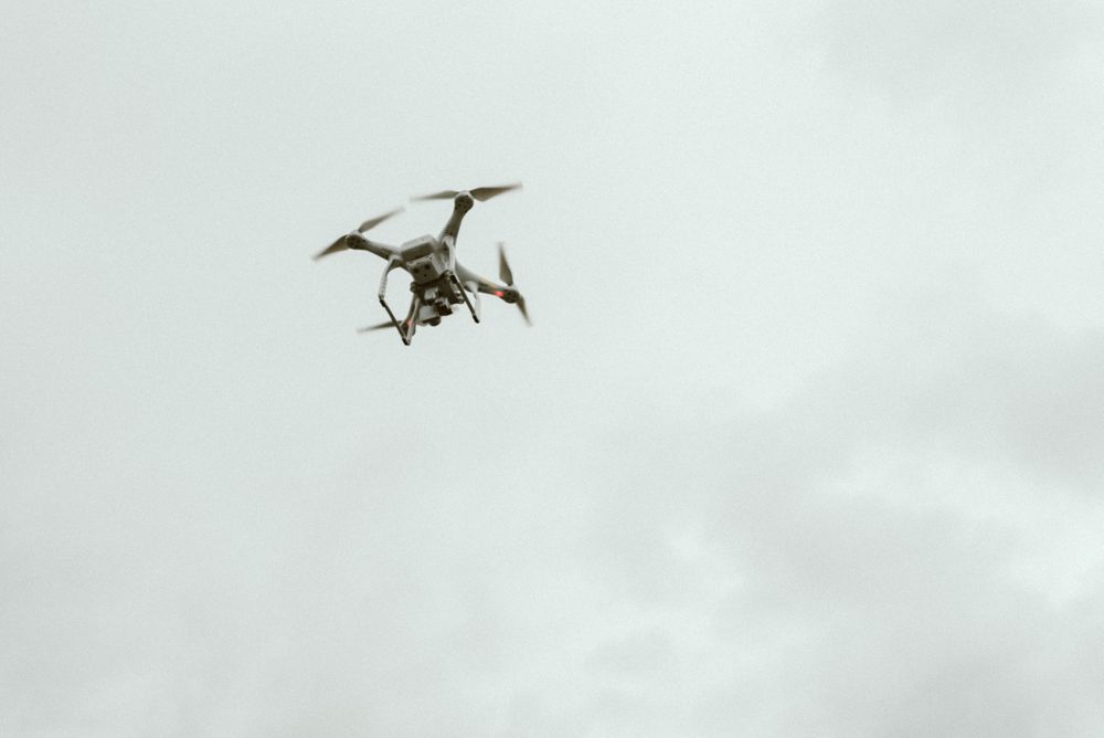 flying drone high in gray sky