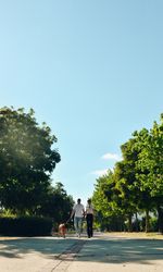 Couple walking and playing with their dog
