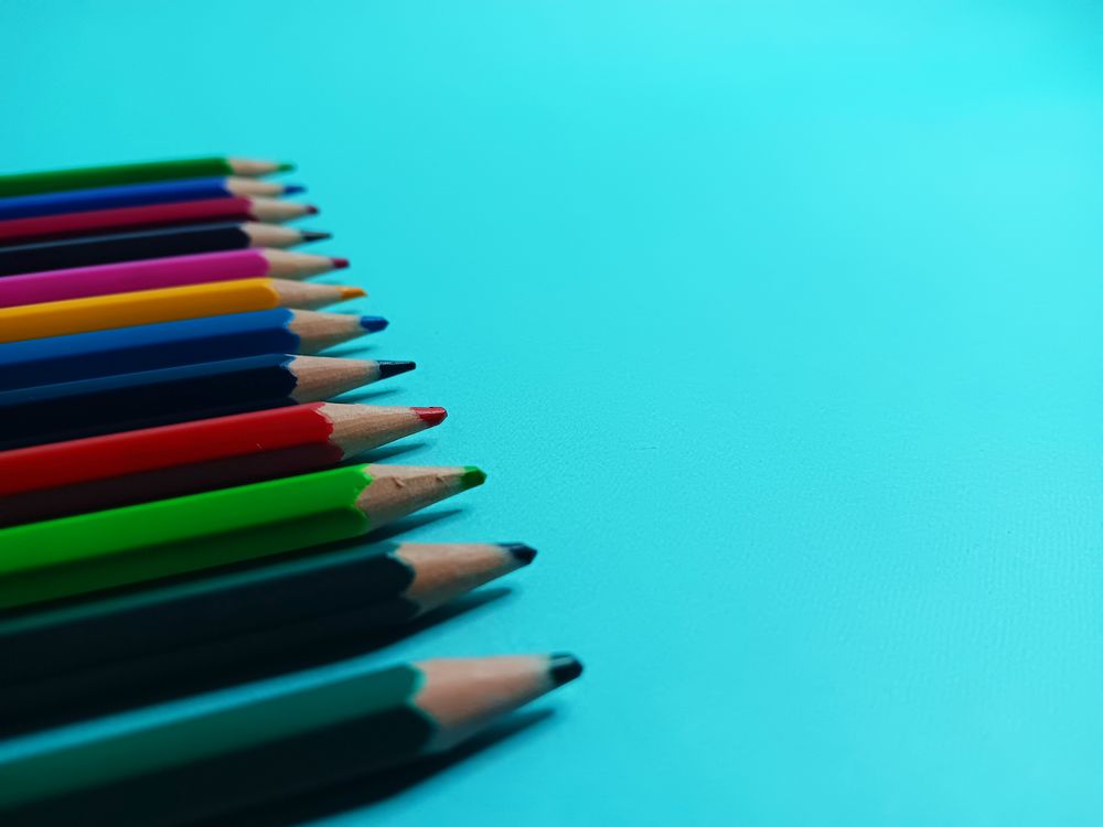 light blue background with wooden color pencils in close up mode