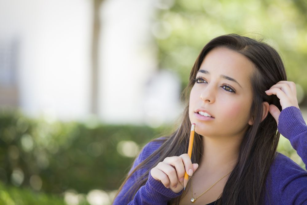 Pensive Female Student with Pencil on Campus