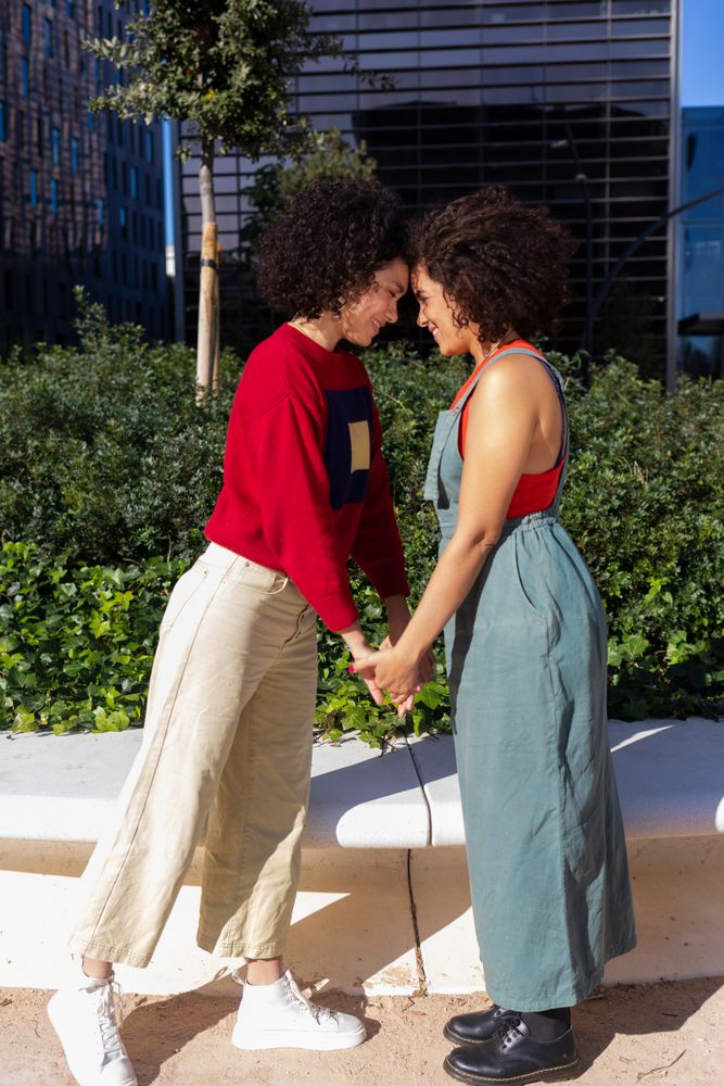 Side view of female couple holding hands and facing each other in park