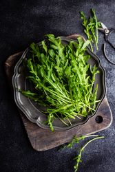Healthy food plate with green arugula leaves