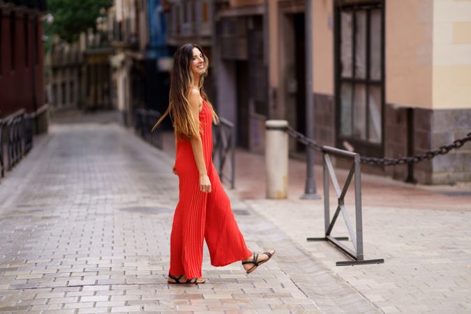 An Elegant Woman Dressed in a Stunning Red Outfit is Strolling Through the Bustling City Streets