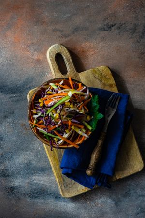 Looking down at fresh salad with finely chopped vegetables in bowl with copy space