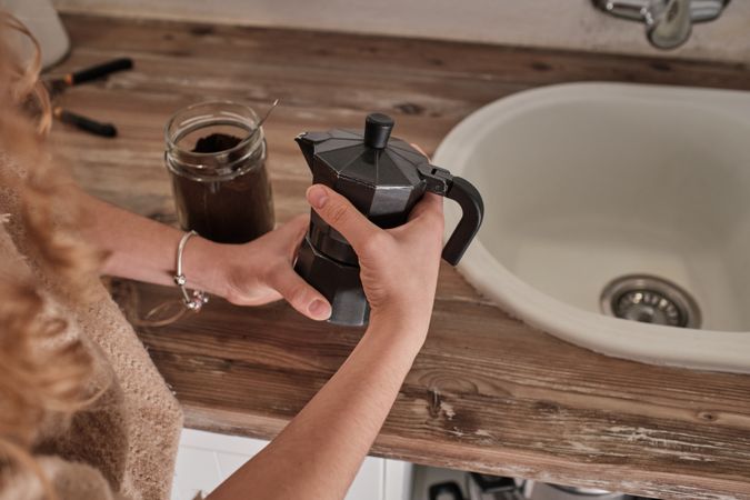 Unrecognizable woman preparing coffee in geyser coffeemaker