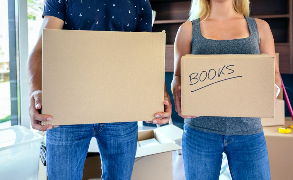 Couple carrying moving boxes