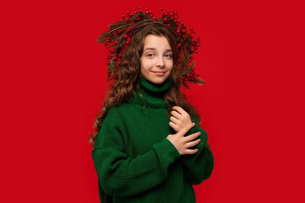 Teen girl in green sweater with Christmas berry wreath