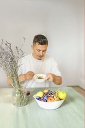 White Man in His 30s Eating Muesli at a Dining Table During Morning Routine.