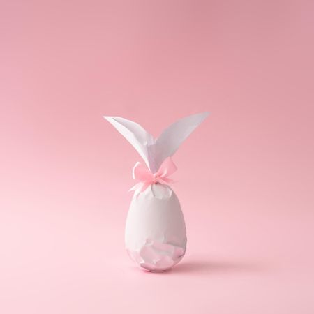 Egg wrapped in light  paper in Easter bunny shape