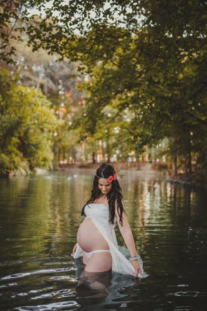 Pregnant woman standing in lake water