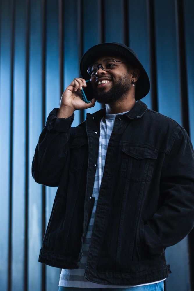 Laughing Black man talking smartphone