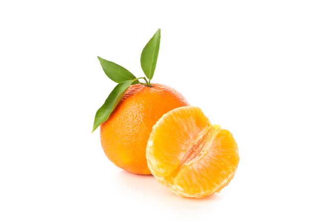 Ripe mandarin with leaves isolated on light background